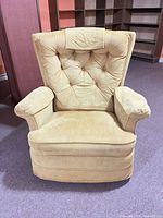 Front view of golden-mustard wingback recliner showing tufted back, rolled arms and skirted base
