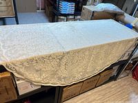 Cream oval lace tablecloth draped on table