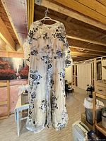 Full view of the sheer embroidered floral lace maxi dress hanging to show length, sleeve style and color details