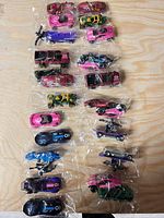 Front view of all eight sealed 3-packs showing all 24 Hot Wheels vehicles