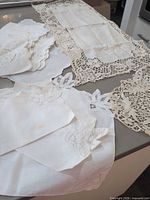 Group view of linen napkins, runner and doilies