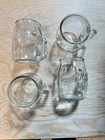Top view of four mason jar handled glasses showing embossed logo