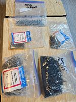 Five plastic bags containing nails and screws laid out on a table