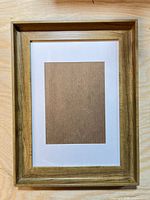 Front view showing faux wood grain frame and white mat