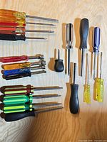 All screwdrivers laid out on wood surface showing quantity and variety