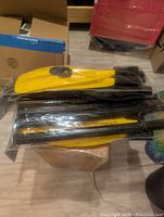 Stack of sealed yellow-bladed oars in plastic sleeves