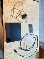 Top view of Sony DVD player with power adapter, remote, HDMI cable displayed