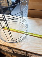 Small tomato cage with measuring tape showing 11.5 in diameter