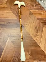 Full view of shoehorn showing handle, wood shaft, and scoop