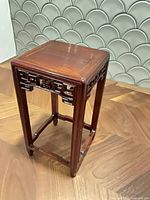 Full view of rosewood pedestal showing overall form and fretwork apron