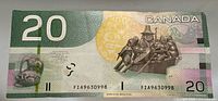 Full reverse view of 2004 Canadian $20 note showing denomination 20, Canoe sculpture artwork, serial number