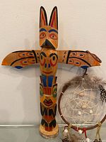 Totem pole front view beside dream catcher