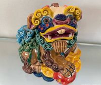 Front three-quarter view of multicolored ceramic Fu Dog figurine