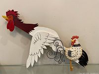 Both rooster wall hangings side by side for size comparison