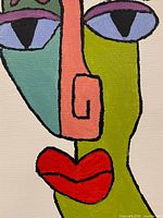 Close-up of painted face showing color blocks and texture