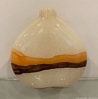 Front view showing flattened ovoid shape, cream body, orange and brown horizontal band