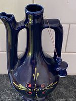 Full view of jug showing cobalt glaze, handles, spout, decorative motif