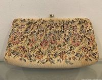 Front view of floral tapestry clutch showing pattern and gold-tone clasp
