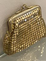 Front view of gold-tone metal mesh coin purse showing mesh pattern and clasp