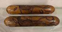 Two wooden clapsticks side by side showing overall size and carvings