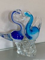 Front view of two-swan glass sculpture showing colours and form