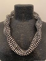 Full view of necklace on display bust showing twisted rhinestone rows