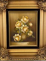 Front view of floral oil painting in gilded frame showing artwork and signature