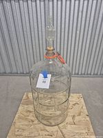 Full view of glass carboy with stopper, airlock, handle