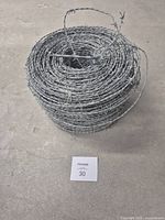 Top view of coiled roll showing handle loop and barbs