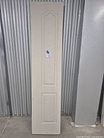 Full view of the primed bifold door showing two-panel arch design and overall condition