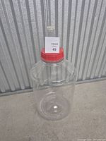 Full view of clear plastic 6 gallon carboy with red cap and assembled airlock