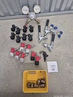 Overview of faucets, disconnects, regulator, picnic tap, fittings in yellow bin