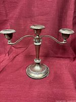 Front view of silver plated three-arm candelabra