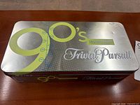Closed metal tin showing 90's Trivial Pursuit branding