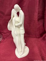 Full front view of white Royal Doulton bride and groom figurine standing on heart-shaped base