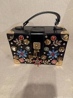 Front view showing floral rhinestone embellishments, padlock clasp, handle