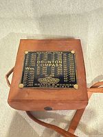 Closed leather case top showing maker plate and natural sines table