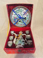 Full set in open box: ewer, six cups, plate, box interior