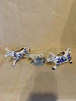 Front view of three Delft-style cow creamers