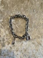 Full view of charm bracelet front showing padlock and flip-flop charms