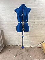 Full view of blue adjustable dress form on tripod stand