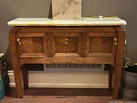 Front view showing three doors, alabaster top, brass pulls