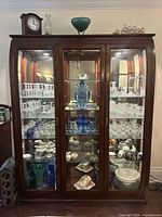 Full view of cabinet showing three glass doors and interior shelves