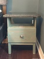 Front view of light green pine nightstand with dark granite top, open shelf, single drawer