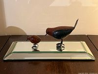 Overall view of mirrored stand with both bird figurines displayed