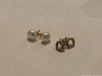 Front view of both pairs: pearl studs and gold knot studs