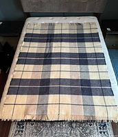 Full view of plaid wool throw blanket on bed