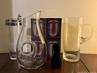 Group shot of all items: tumbler boxes, decanter, cocktail shaker, pitcher, pouch