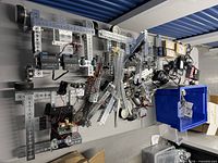 Overall view of aluminum frames, motors, controllers, wheels, boxes, cables and blue bin