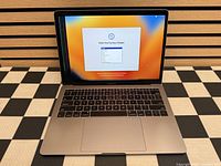 MacBook Pro open on setup screen, visible stripe defect on left side of display